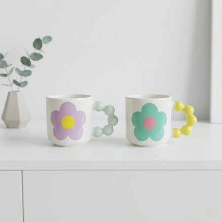 مج سيراميك ابيض برسم زهرة مع يد بتصميم بابلز